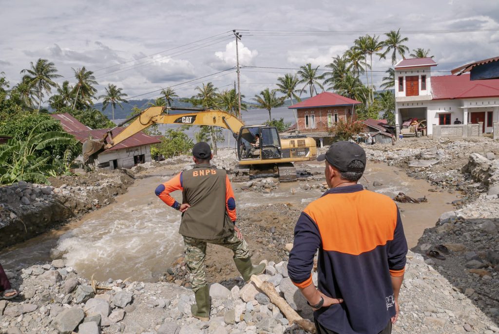 Pekerja mengoperasikan alat berat saat membersihkan material banjir bandang dan tanah longsor di Nagari Guguak Malalo, Kabupaten Tanah Datar, Sumatera Barat, Selasa (2/12/2025). Akses menuju Nagari Padang Laweh dan Guguak Malalo sempat terputus dari wilayah sekitar, sehingga proses evakuasi warga dilakukan melalui jalur Danau Singkarak. (Antara/Wawan Kurniawan)