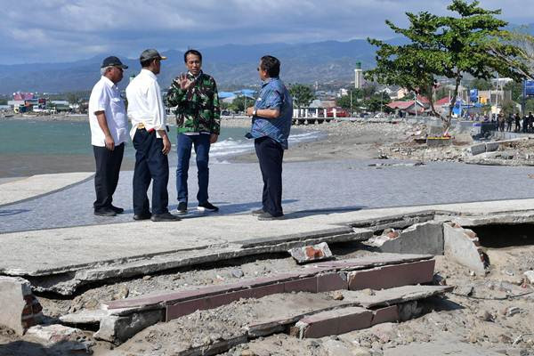 Presiden Joko Widodo (berjaket loreng) berdiskusi bersama Menteri PUPR Basuki Hadimulyono (kiri), Menko P{olhukam Wiranto (kedua dari kiri), dan Gubernur Sulawesi Tengah Longki Djanggola (kanan) saat meninjau kondisi akibat gempa bumi dan tsunami di Palu, Sulawesi Tengah, 2018. (bisnis.com)