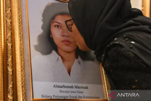 Adik aktivis buruh Marsinah, Wijiyati, mencium foto kakaknya usai mengikuti upacara pemberian gelar pahlawan kepada Marsinah dan sembilan tokoh lainnya di Istana Negara, Jakarta, Senin (10/11/2025). (Foto: Antara/Aditya Pradana Putra)