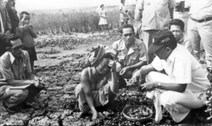 Sekretaris Pengendalian Operasional Pembangunan (Sesdalopbang) Solihin G.P. berbincang dengan warga dalam sebuah peninjauan lapangan di Karawang, Jawa Barat, 1977. (Foto: Kompas/Her Suganda)